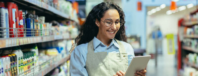 DRUID Retail Profi Case Study Agentic AI showing a grocery store worker smiling